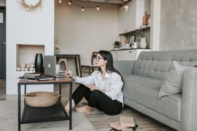 woman sitting on the floor while using her macbook